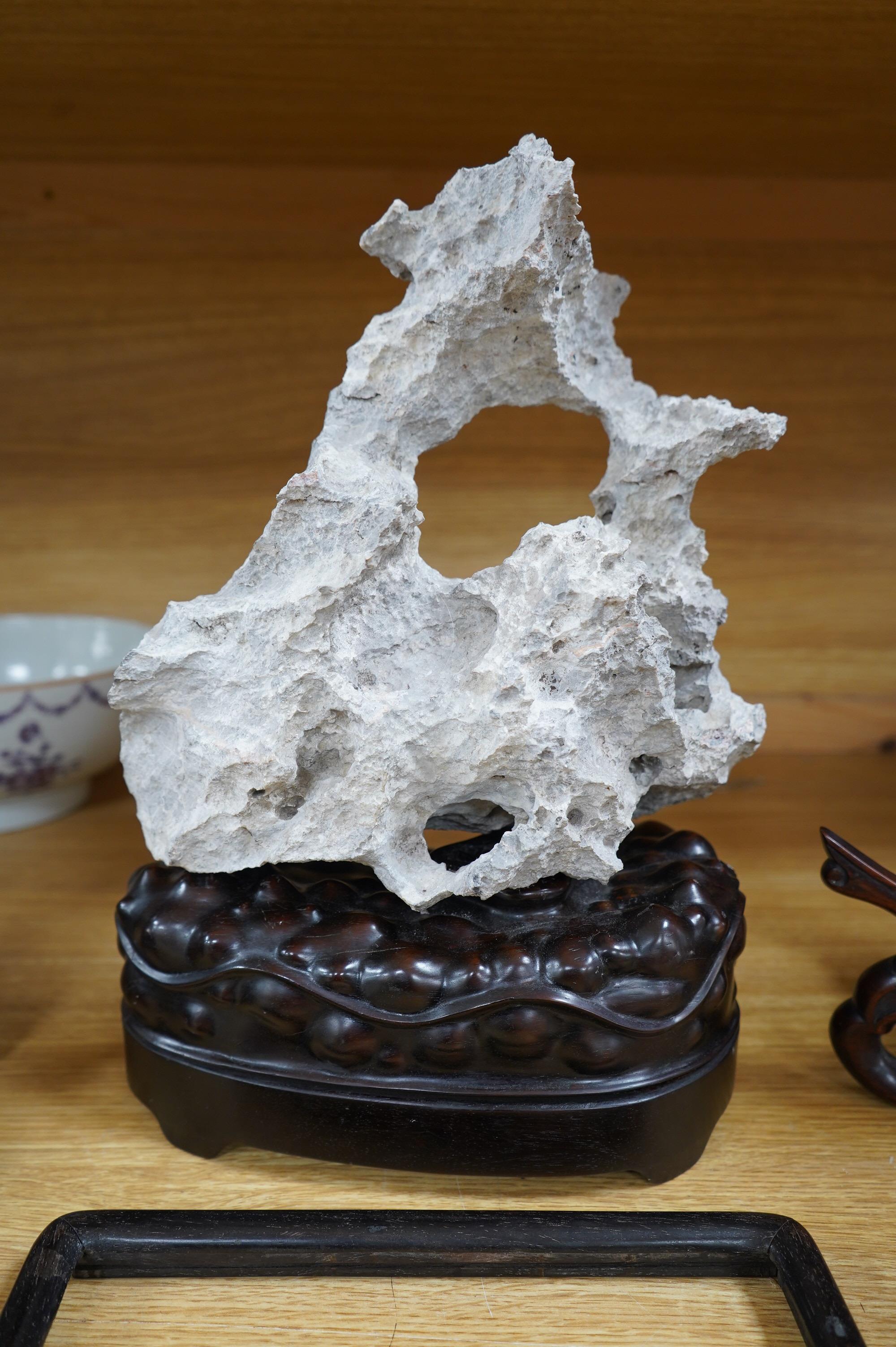 A Chinese grey stone scholar's rock, on stand, together with two Chinese hardwood plate stands and small hardwood frame, largest overall 38cm high. Condition - fair to good